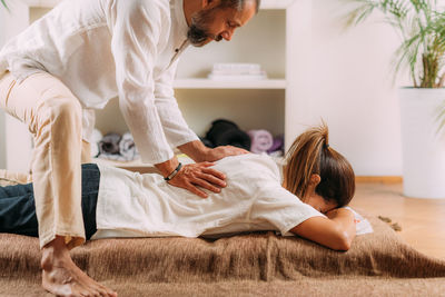 Woman enjoying shiatsu back massage, lying on the shiatsu massage mat.