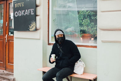 Man sitting with coffee cup on bench