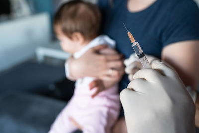 Close-up of doctor holding syringe