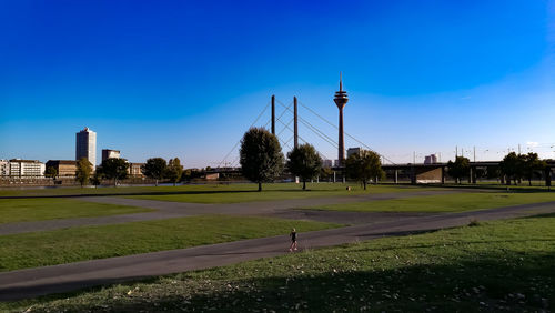 Park by buildings against blue sky