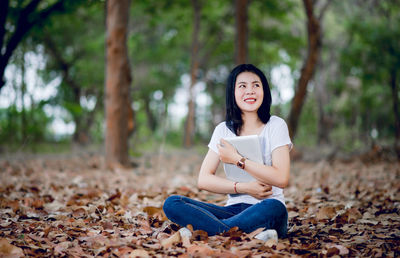 Portrait of smiling young woman sitting outdoors