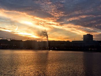 Scenic view of river against sky at sunset