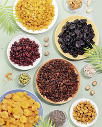 Dry fruits, nuts and seeds assortment on a blue background