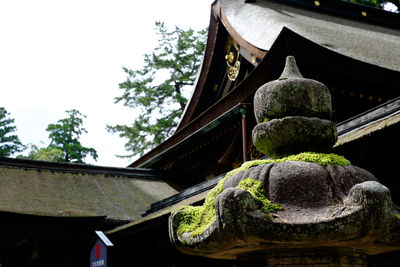 High section of house in front of trees against sky