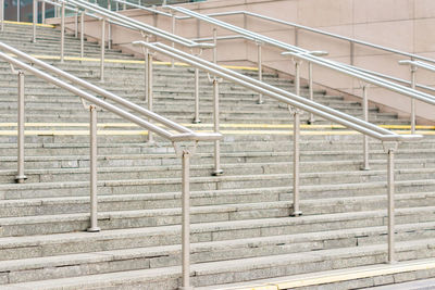 View to outdoor steps with metal railing in center of leading to entrance into modern building