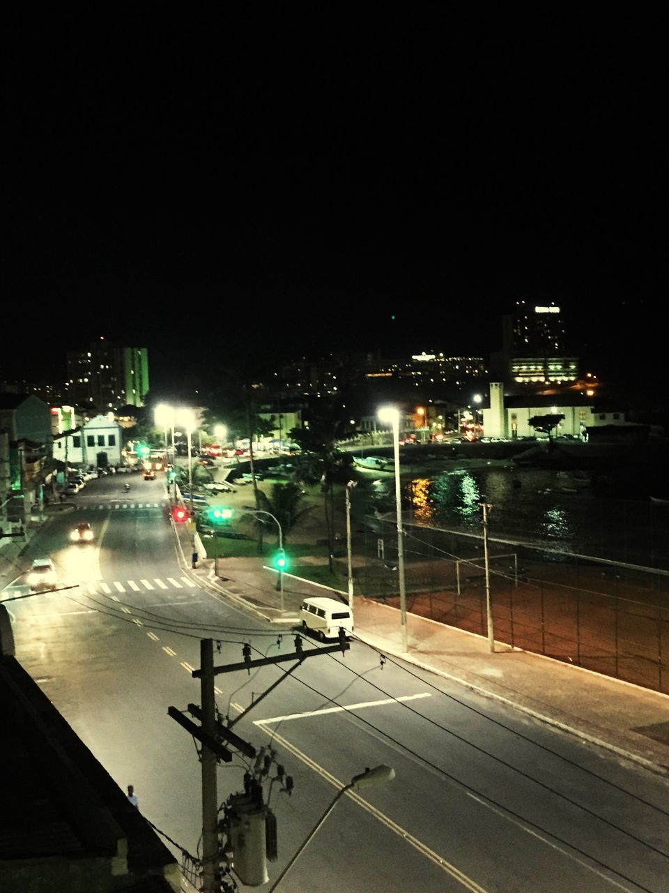 illuminated, night, city, transportation, road, building exterior, built structure, architecture, street, street light, road marking, car, city life, lighting equipment, clear sky, outdoors, city street, high angle view, sky, copy space