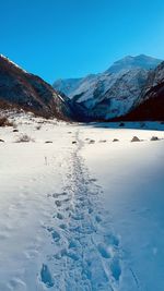 Scenic view of snowcapped mountains against blue sky