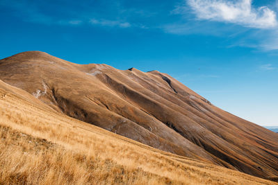 Low angle view of arid landscape against sky in castelluccio, umbria italy 