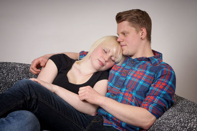 Young couple sitting on sofa at home