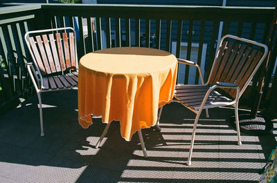 Empty chairs and tables at sidewalk cafe