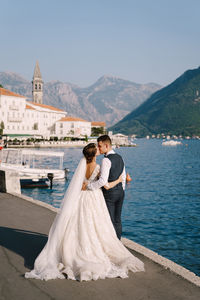 Rear view of couple holding hands in water