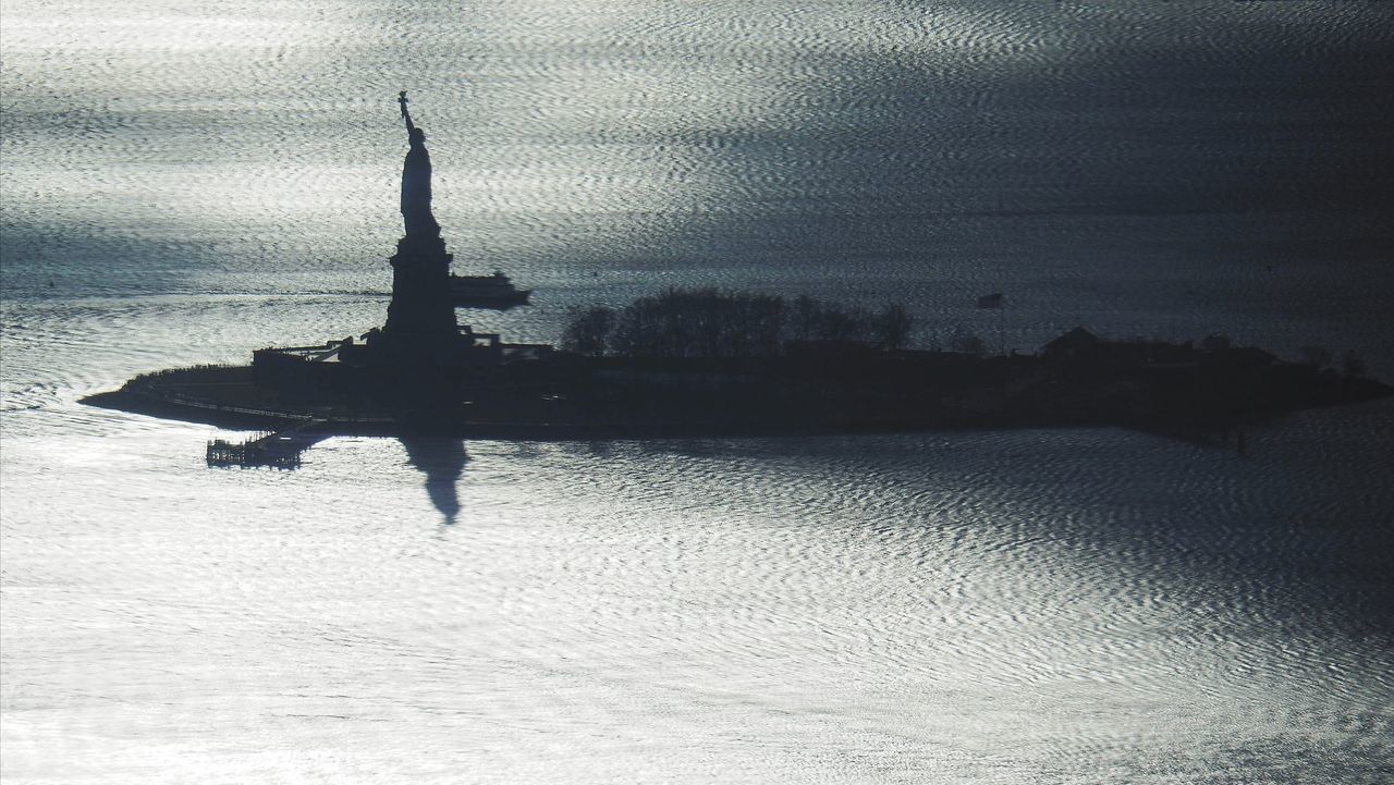 SILHOUETTE OF BUILDING AGAINST CLOUDY SKY