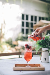 Cropped hand of woman pouring wine in glass