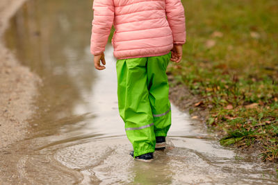 Low section of woman standing on wet road