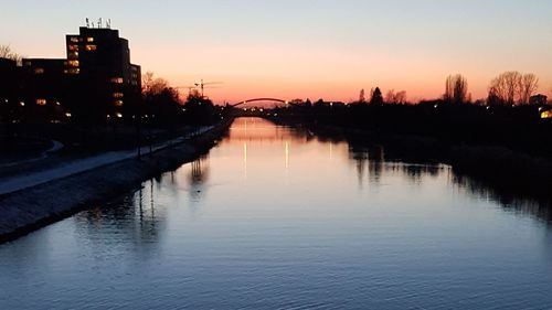 Scenic view of river against sky at sunset