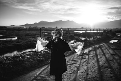 Woman standing on water against sky