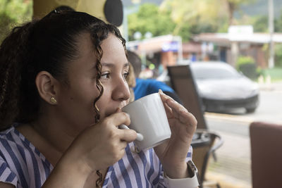 Latin woman drinking coffee