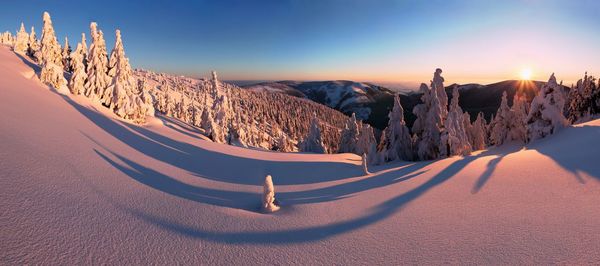 Panoramic view of snowcapped mountains against sky during sunset
