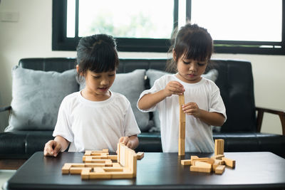 Boy playing with toy sitting on table