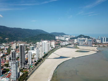 High angle view of city by sea against sky