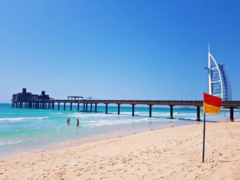 Scenic view of beach against clear blue sky