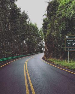 Road amidst trees against sky