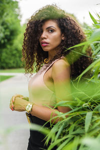 Portrait of woman standing by plants