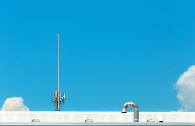 Low angle view of communications tower against blue sky