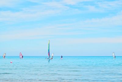 People in sea against sky