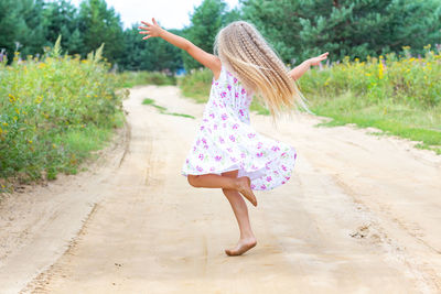 Full length of woman with arms raised