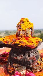 Close-up of bonfire on rock against sky