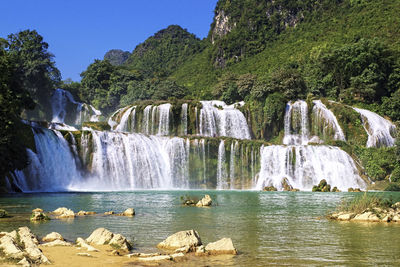 Scenic view of waterfall against sky