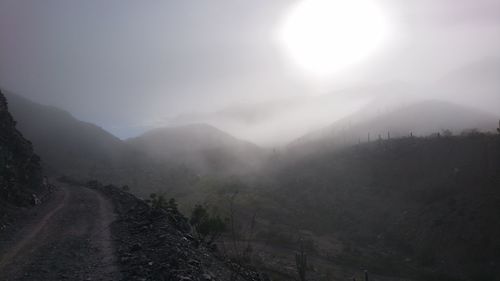 Scenic view of mountains against sky during foggy weather