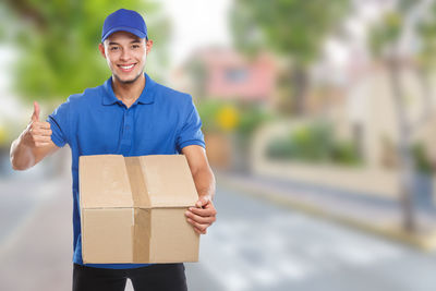 Portrait of young man holding camera in box