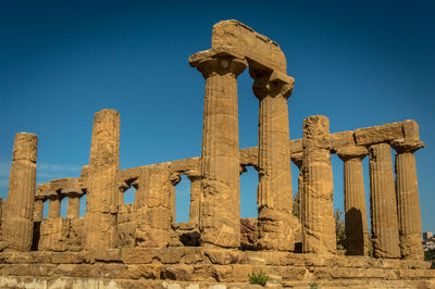 Low angle view of old ruins against blue sky