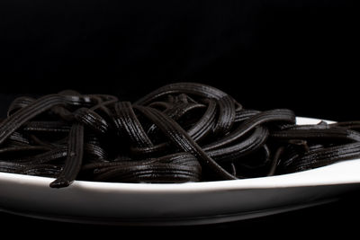 Close-up of rope on table against black background