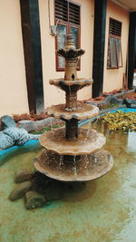 Close-up of old fountain against building