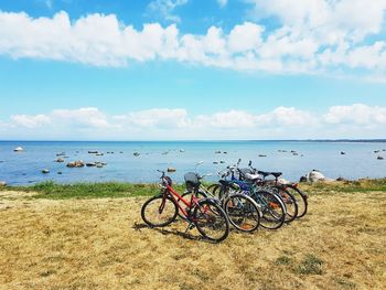 Bicycles on beach against sky