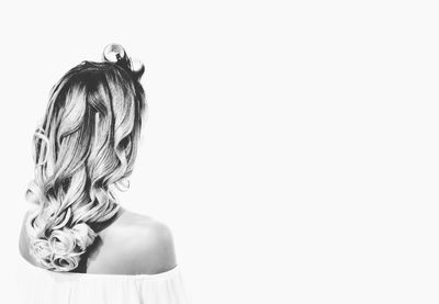 Rear view of girl standing against white background