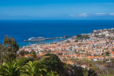 High angle view of townscape by sea against sky