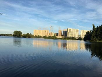 Scenic view of lake by buildings against sky