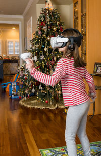 Rear view of young woman standing at home