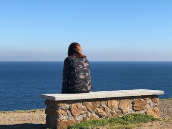 Rear view of woman looking at sea against sky