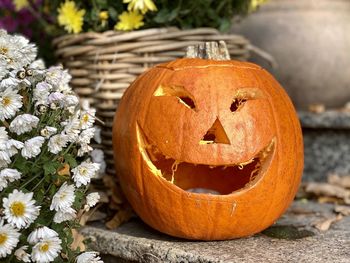 Close-up of pumpkin against orange flower pot