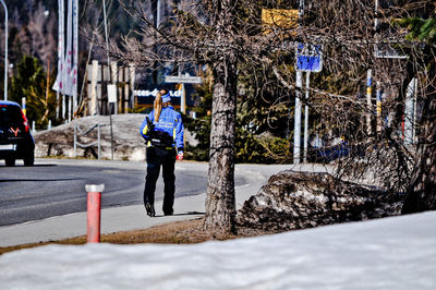 Full length of man walking on street in city during winter