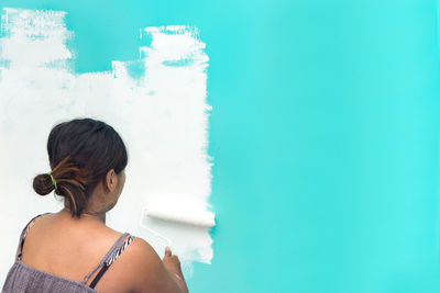 Rear view of woman standing against blue sky