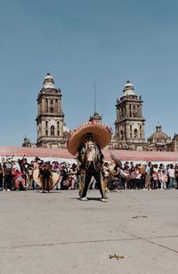 Rear view of people in front of historic building