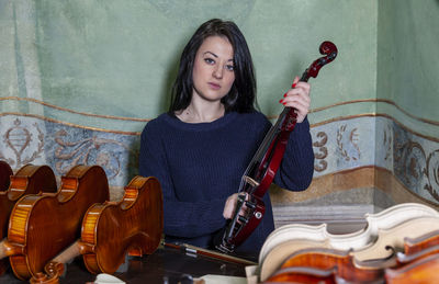 Fascinating violinist showing his collection of handcrafted violins at home