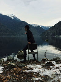 Woman on lake against mountains