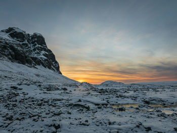 Scenic view of snow covered mountains against sky during sunset